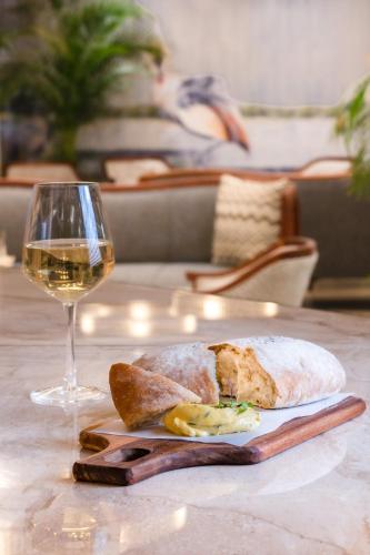 a plate of food and a glass of wine on a table at African Pride Melrose Arch, Autograph Collection in Johannesburg