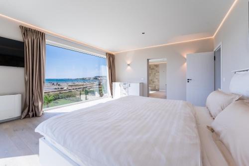 um quarto com uma grande cama branca e uma grande janela em Ljubac Seaside em Ražanac