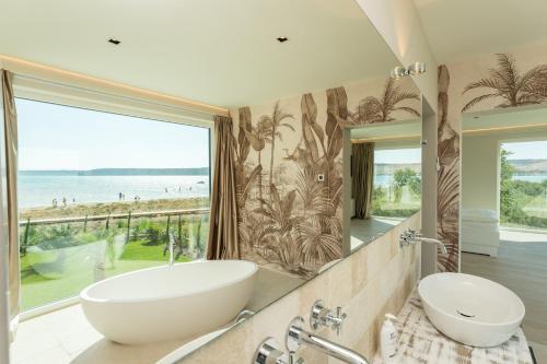 uma casa de banho com 2 lavatórios e uma grande janela em Ljubac Seaside em Ražanac
