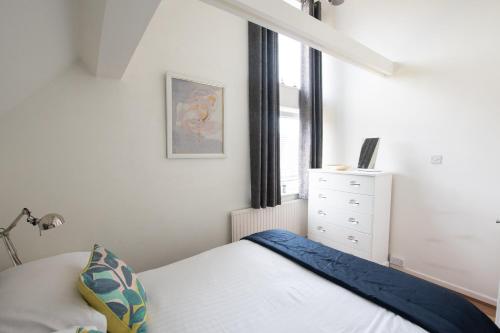 a small bedroom with a bed and a window at The Penthouse Canterbury - Cathedral View in Canterbury