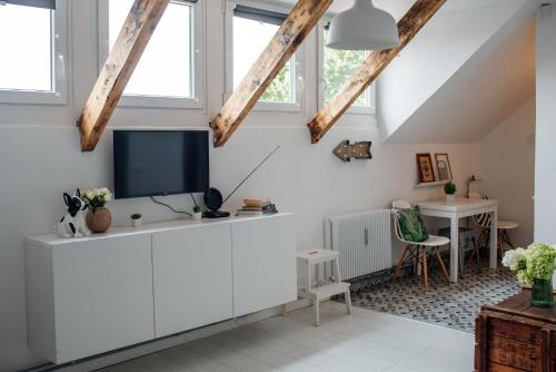 a living room with a tv on a white cabinet at Belváros Apartman in Veszprém