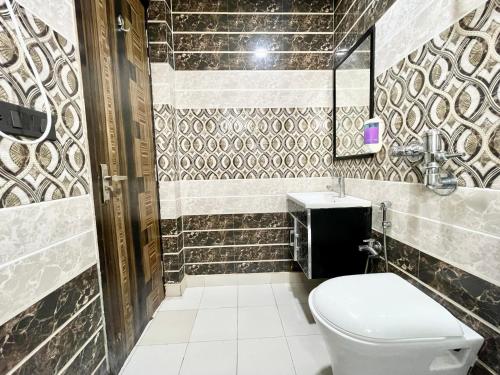 uma casa de banho com um WC e um lavatório em The Grand Suite-70 em Noida