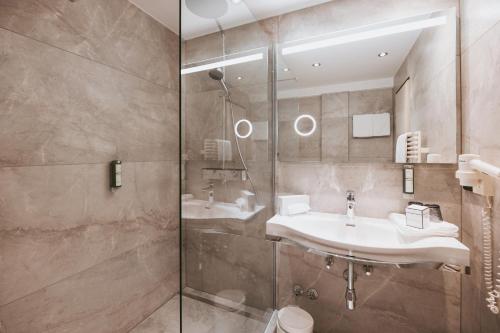 a bathroom with two sinks and a shower at MANNI das Hotel in Mayrhofen