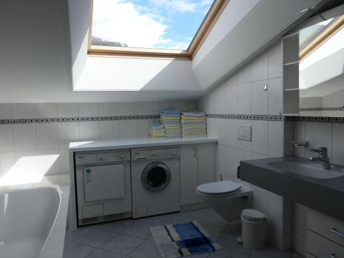 ein Bad mit einer Waschmaschine und einem Fenster in der Unterkunft Fewo Schrottenbaum in Bürs