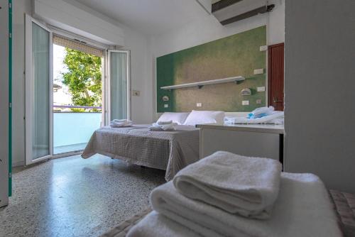 1 dormitorio con cama, espejo y toallas en Hotel Baltic en Gabicce Mare