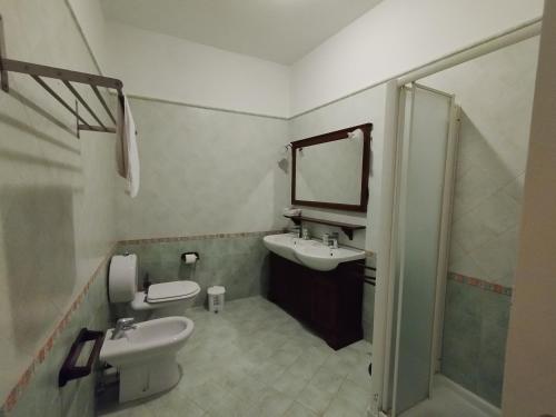 a bathroom with a sink and a toilet and a mirror at Villa Terrauzza in Siracusa