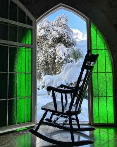 a rocking chair sitting in front of a window at Stone Cellars in Douma