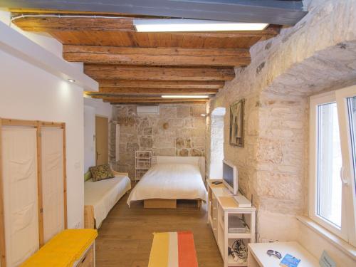 - une chambre avec un lit et une télévision dans l'établissement Apartments Stelina, à Korčula