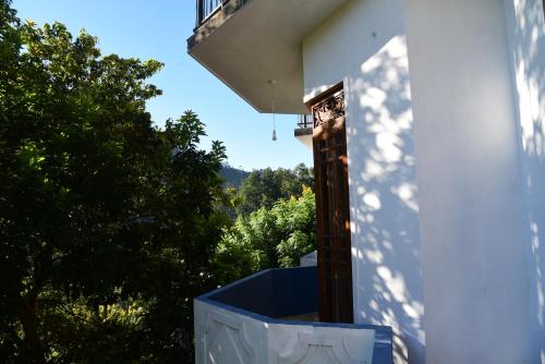 een uitzicht vanaf het balkon van een huis met bomen bij 9 Hills Ella in Ella