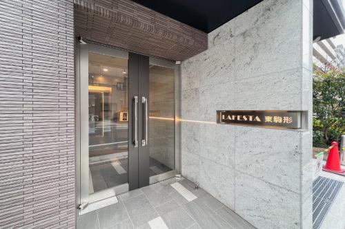 a entrance to a building with a sign on it at Lafesta Higashikomagata in Tokyo