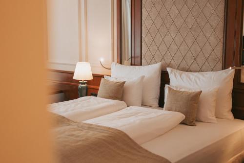 2 Betten mit weißer Bettwäsche und Kissen in einem Zimmer in der Unterkunft MANNI das Hotel in Mayrhofen