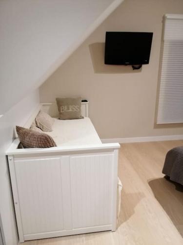 a white room with a bed and a flat screen tv at Akkerland - Luxe vakantiehuisje met Infra-Rood sauna - 2 à 6 pers in Zonnebeke