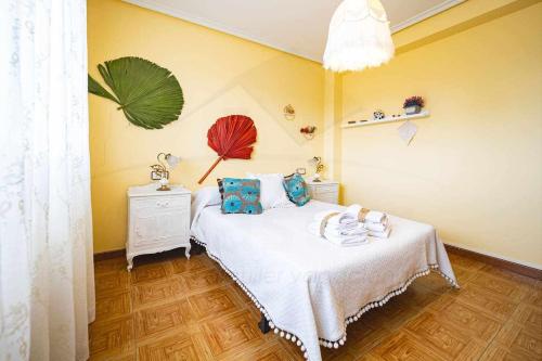 um quarto com uma cama com um cobertor branco e almofadas azuis em La Huertina De Granda em Candanal
