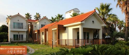a row of houses with an orange roof at Jeju Soranghozen Pension in Seogwipo