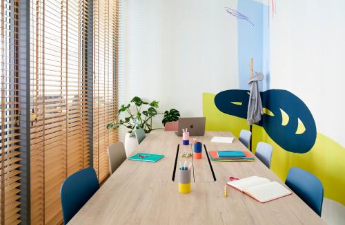 a dining room with a wooden table with blue chairs at INNSiDE by Meliá Zaragoza in Zaragoza