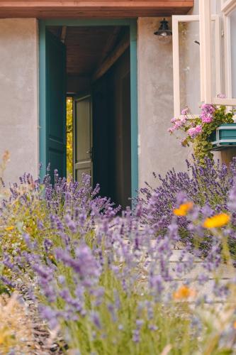 a house with purple flowers in front of a door at Domeček na Květinovém statku in Zdice