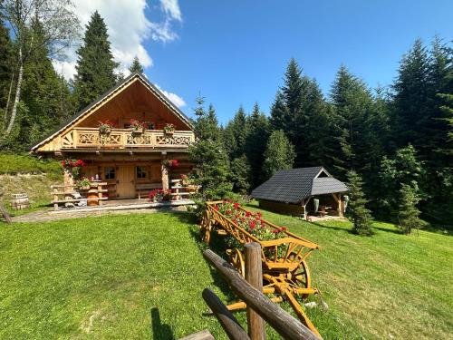 a log cabin with a table in front of it at Leśna Bacówka in Nowy Targ