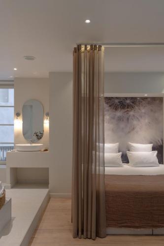 a bedroom with a bed with a painting on the wall at MiHotel Sala in Lyon