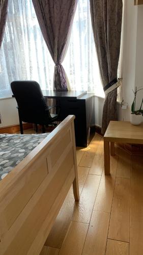 a living room with a chair and a table and a window at Home from Home in London