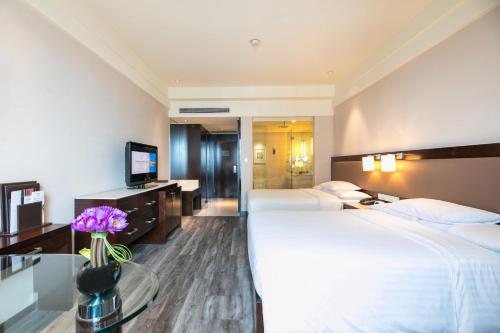 a hotel room with two beds and a television at Courtyard by Marriott Hangzhou Wulin in Hangzhou