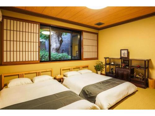 - 2 lits dans une chambre avec fenêtre dans l'établissement Shirakabanoyado Izumi - Vacation STAY 95387v, à Izumi-Sano