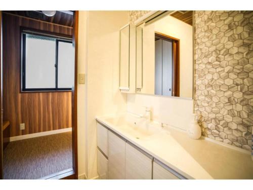 La salle de bains est pourvue d'un lavabo et d'un miroir. dans l'établissement Shirakabanoyado Izumi - Vacation STAY 95387v, à Izumi-Sano