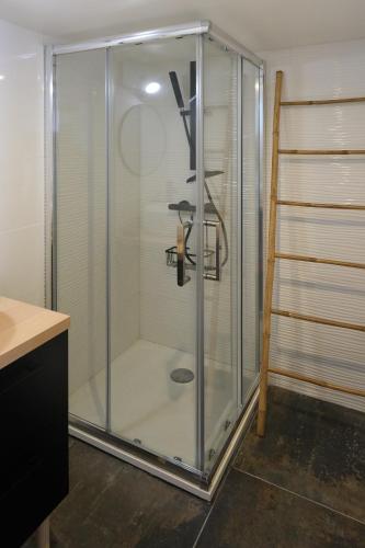 une douche avec une porte vitrée dans une salle de bain dans l'établissement vacance en bord de mer, à La Ciotat