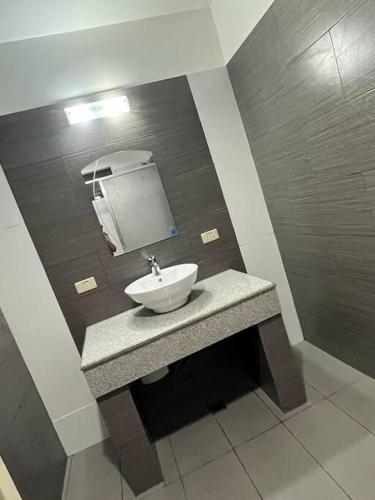 a bathroom with a sink and a mirror at My Suite Heart of San Juan City Near Ortigas in Manila