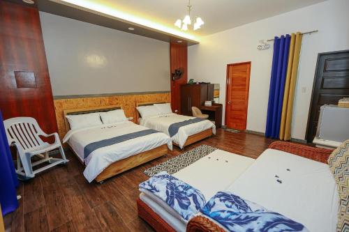a hotel room with two beds and a chair at B Ternate Resort in Dauin