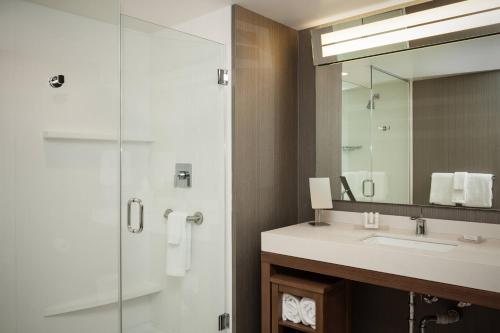 a bathroom with a sink and a shower with a mirror at Courtyard by Marriott Walla Walla in Walla Walla