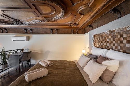 Szent István Apartments في بودابست: غرفة نوم بسرير كبير بسقف خشبي