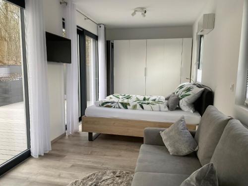 een woonkamer met een bed en een bank bij Ferienhaus Residenz am Stausee in Schotten