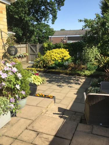 a garden with flowers and a patio at Forest B & B in Ringwood