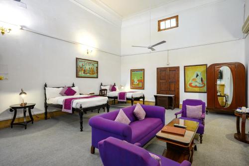 a room with a purple couch and a bed at Neemrana's - Baradari Palace in Patiāla