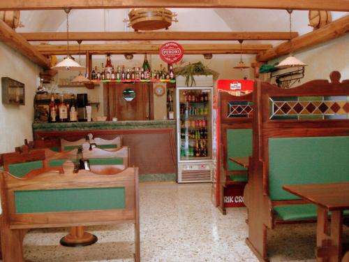 a restaurant with a bar with a table and a refrigerator at Hotel Ristorante da Righetto in Campagnano di Roma