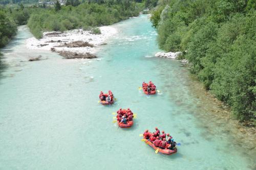 a group of people in boats on a river at 7 Flower Street Apartment in Šempeter pri Gorici