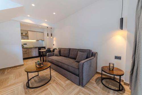 Dream Luxury Apartments في ستافروس: غرفة معيشة مع أريكة وطاولتين
