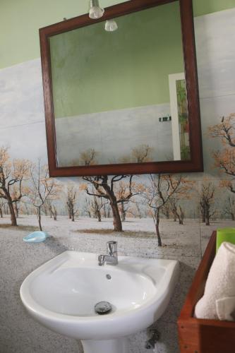 baño con lavabo, espejo y árboles en Dinuli home stay, en Ahungalla