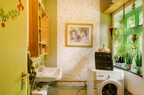 een badkamer met een wasmachine en een wastafel bij Fairy Cottage in Rhauderfehn