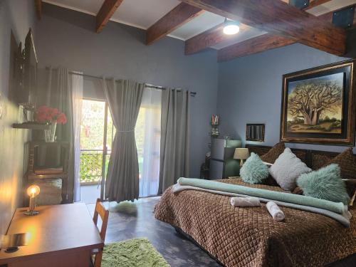 a bedroom with a bed and a table and a window at Suikerbosrant Sleep and go in Pretoria
