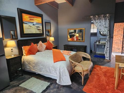a bedroom with a large bed with orange pillows at Suikerbosrant Sleep and go in Pretoria