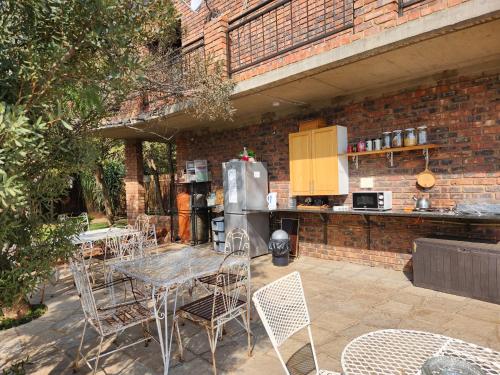 a patio with a table and chairs and a kitchen at Suikerbosrant Sleep and go in Pretoria