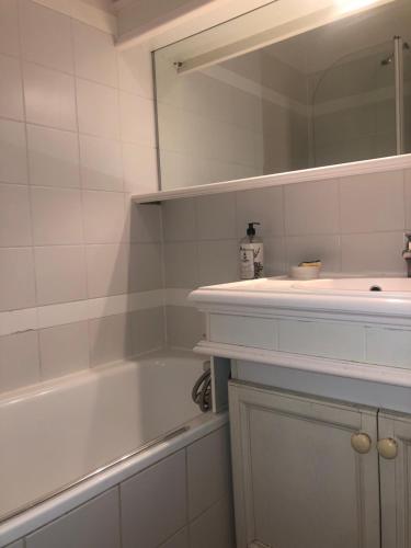 une salle de bain avec une baignoire, un lavabo et un miroir dans l'établissement Magnifique vue lac au Golf de Pont-Royal, à Mallemort