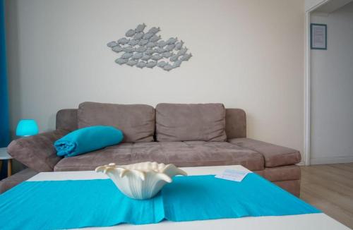 - un salon avec un canapé et une couverture bleue dans l'établissement Bellevue-Haus-C-Wohnung-21, à Großenbrode