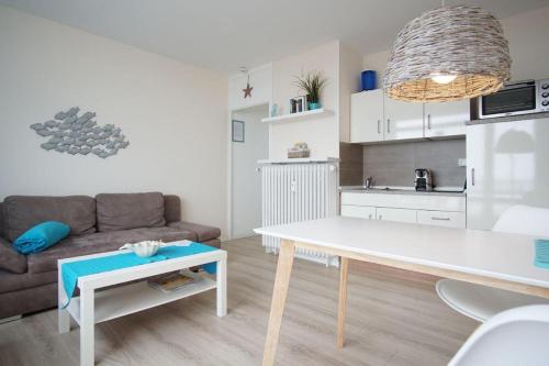- un salon avec une table blanche et un canapé dans l'établissement Bellevue-Haus-C-Wohnung-21, à Großenbrode