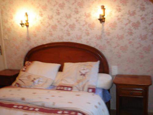 Schlafzimmer mit einem Bett mit einem Kopfteil aus Holz und einem Tisch in der Unterkunft Lieu dit kerleo in Melgven