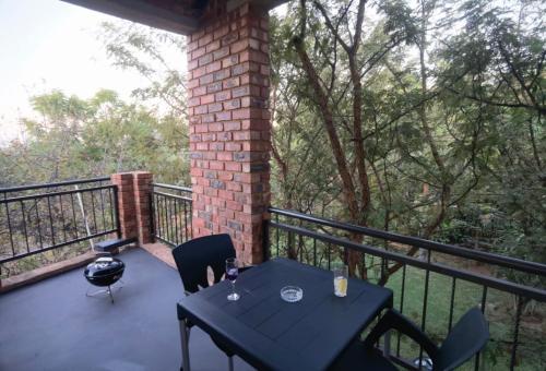 a patio with a table and chairs on a balcony at Suikerbosrant Sleep and go in Pretoria