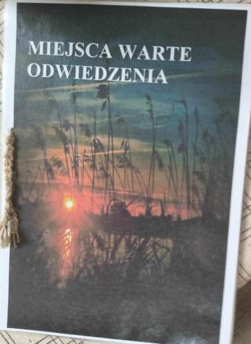 a book with a picture of a sunset at Pokoje u Izy Stare Kiejkuty in Szczytno