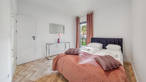 a bedroom with a bed and a tv on the wall at Apartamenty Sun & Snow Belnihel in Hel
