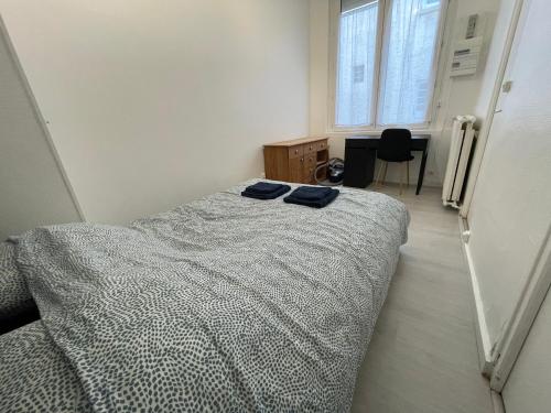 ein Schlafzimmer mit einem Bett mit zwei blauen Handtüchern darauf in der Unterkunft Appartement à 200 mètres de la gare in Rouen